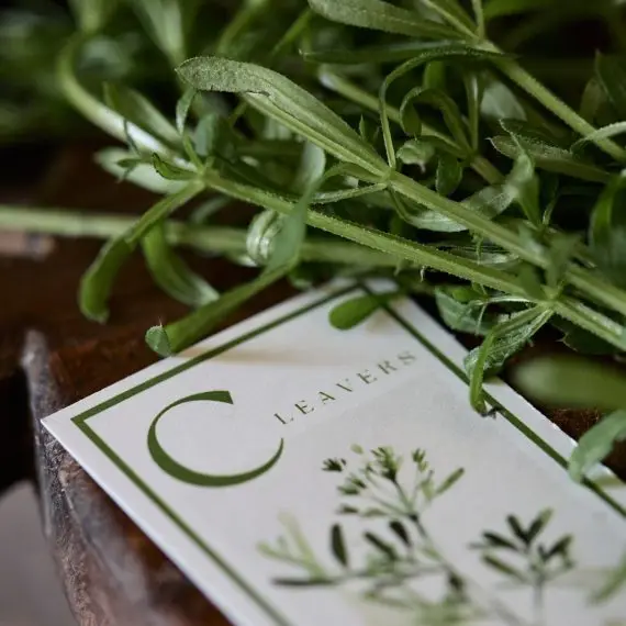 Cleavers on a chopping board with a card saying Cleavers