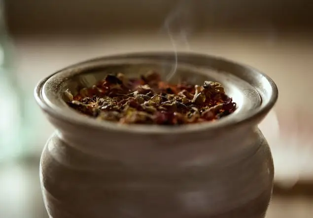 A herbal mixture smokes in a wax melt burner