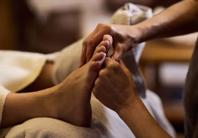 A hand massages a foot for Reflexology