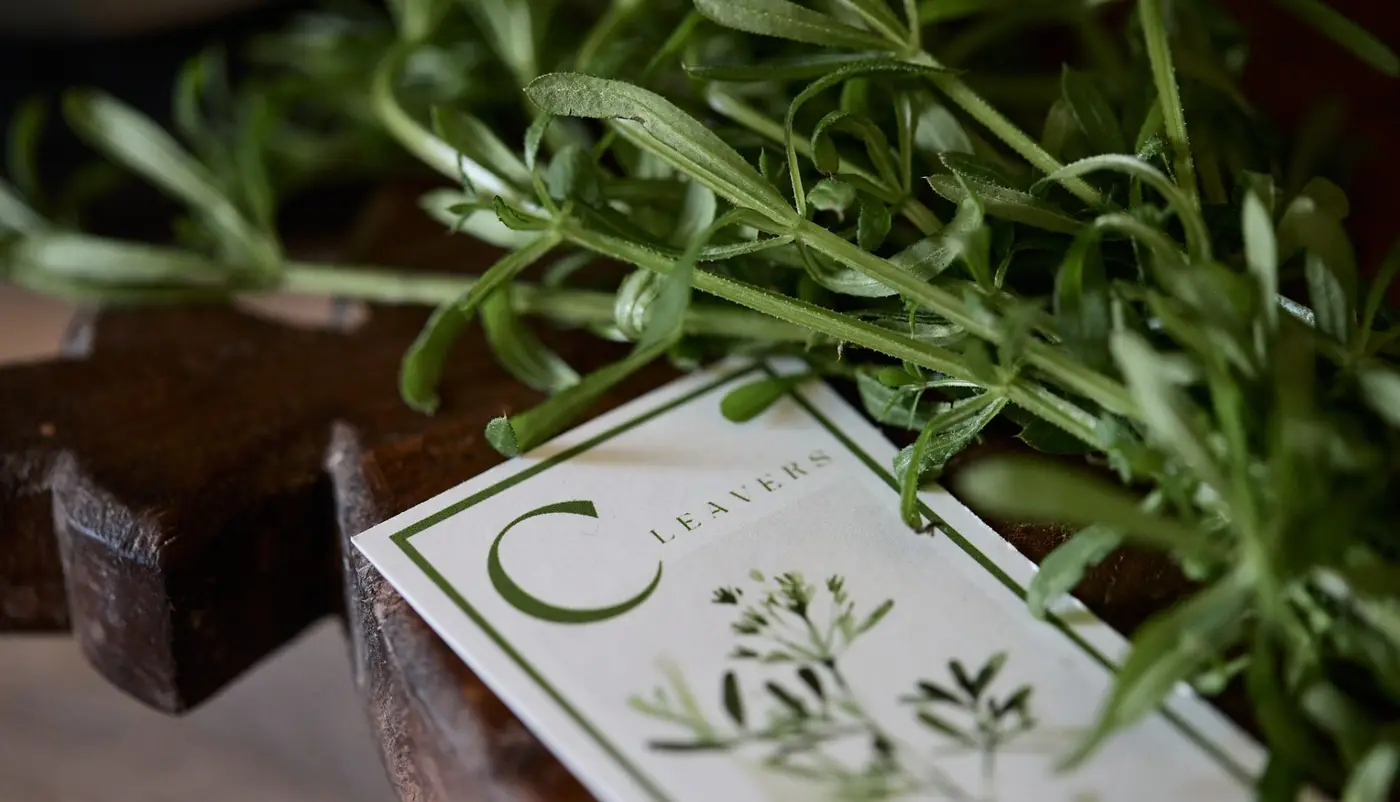 Cleavers on a chopping board with a card saying Cleavers