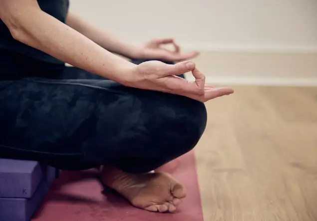 A closeup of a seated woman's hands while she meditates