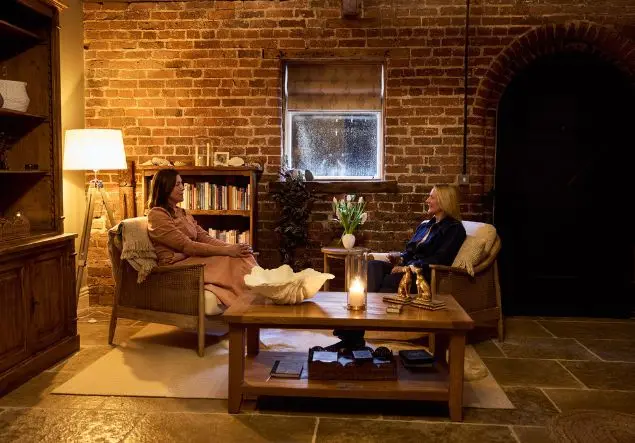 Two women having a conversation in a warmly lit room