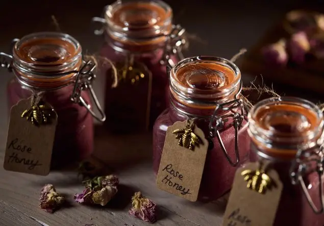 A collection of pink rose honey labelled jars